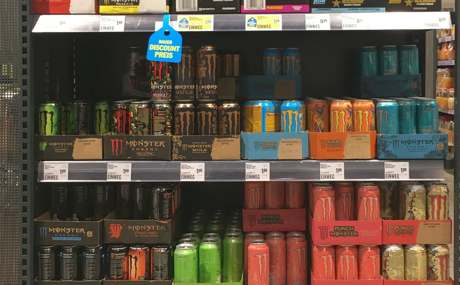 Rayon de supermarché rempli de canettes de boissons énergisantes de plusieurs marques